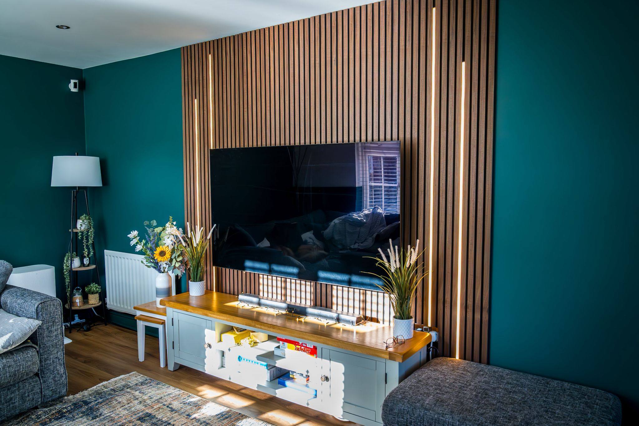 Teal living room with bespoke wood-slat feature wall and integrated lighting