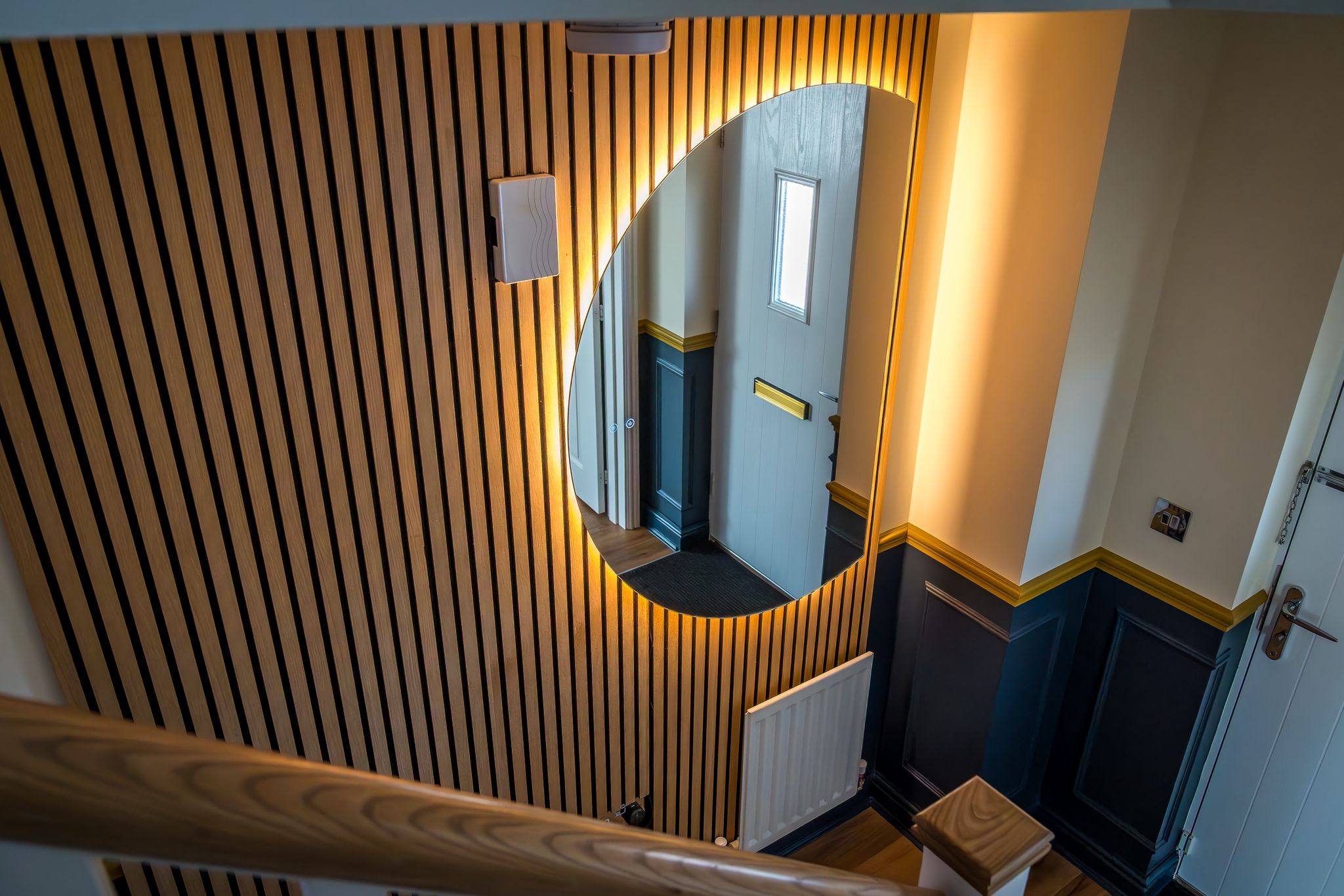 Hallway slat panelling with mirror cutout, viewed from staircase